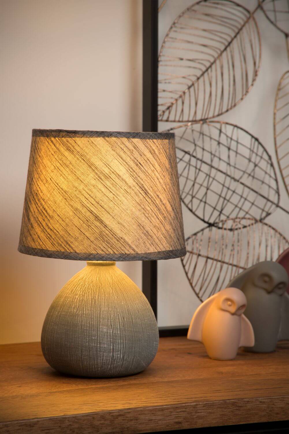 Mise en ambiance : lampe allumée près de figurines de hiboux et cadre décoratif.