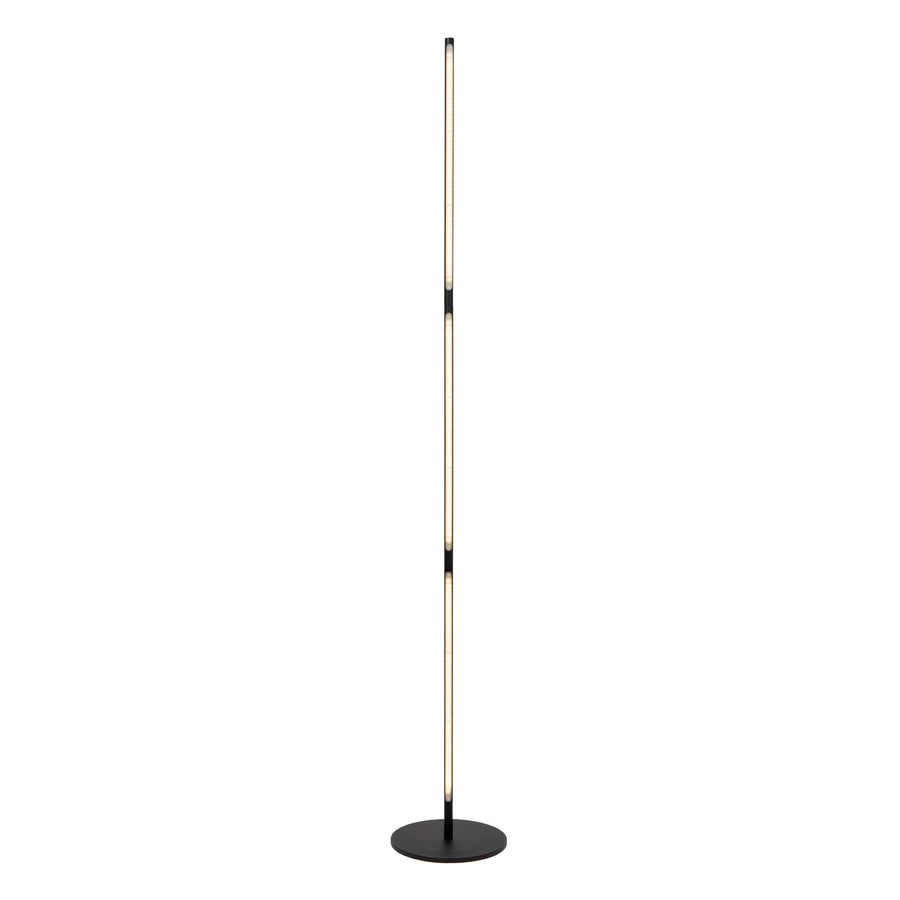 Lampadaire en situation, lumière chaude diffuse éclairant le mur derrière.