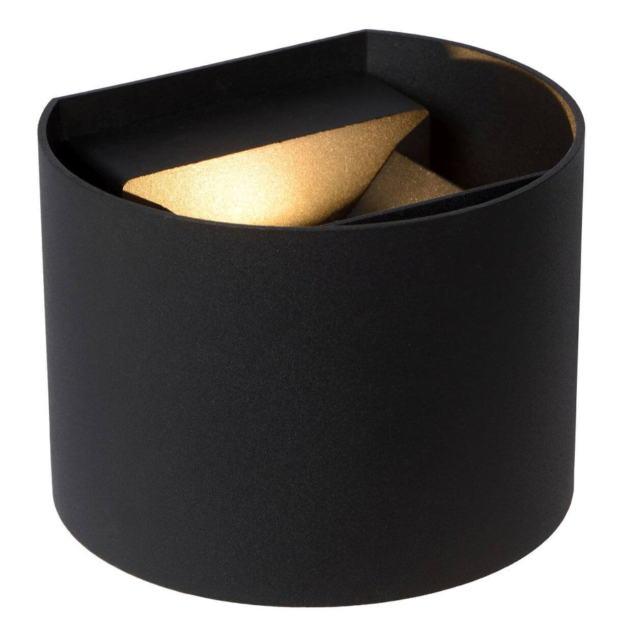 Produit sur fond blanc : applique cylindrique noire, intérieur doré, éclairage vers le haut.