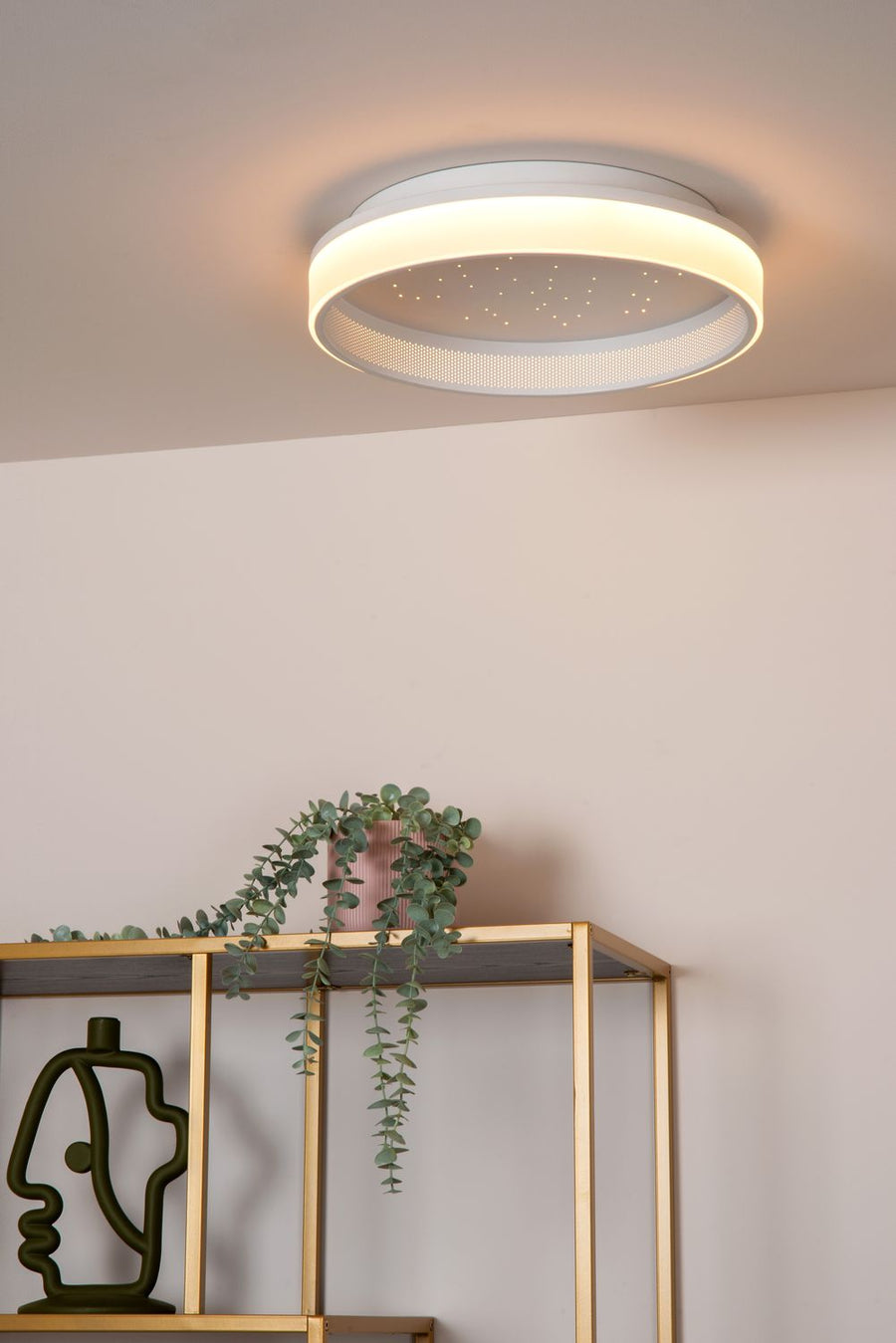 Vue rapprochée du plafonnier blanc allumé, bord lumineux diffusant une lumière chaude
