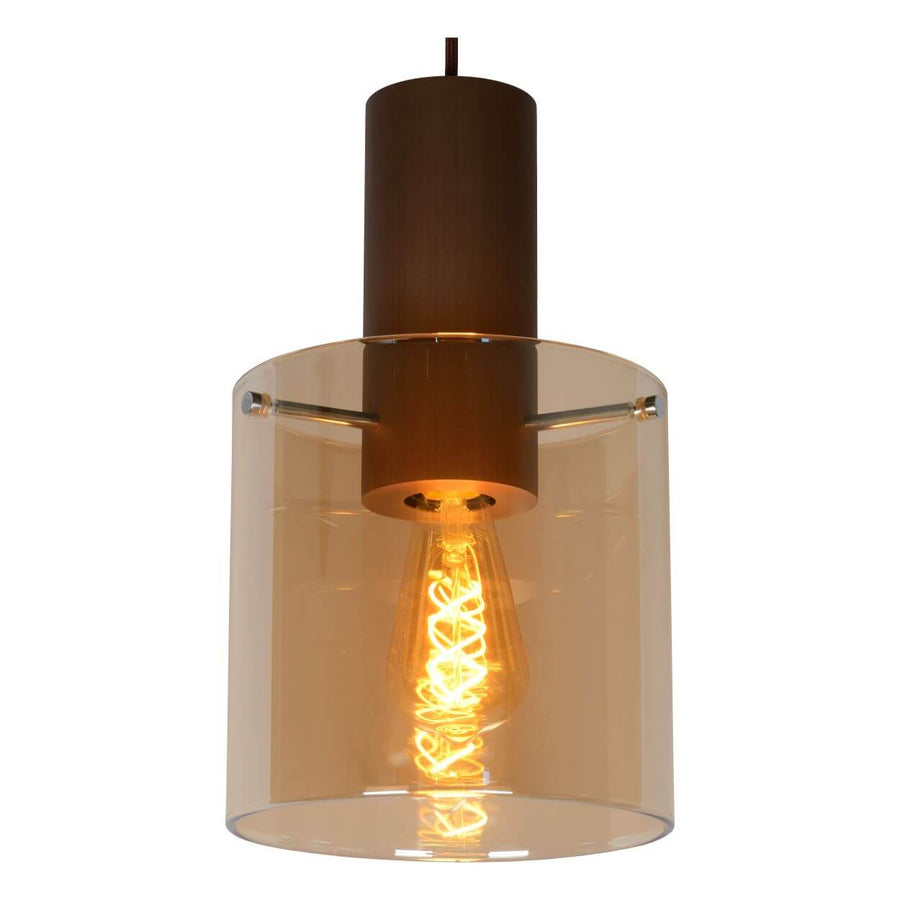 Gros plan sur un abat-jour cylindrique en verre ambré, douille cuivrée et ampoule filament.
