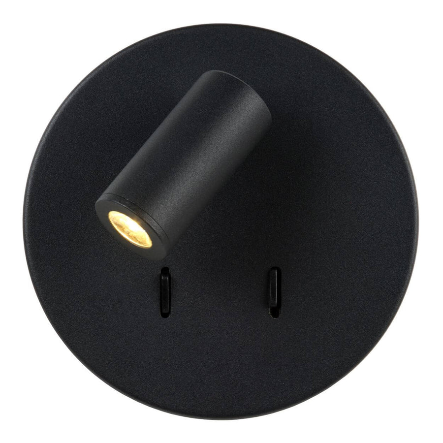 Vue de face du luminaire allumé, projecteur incliné et halo doré sur la platine