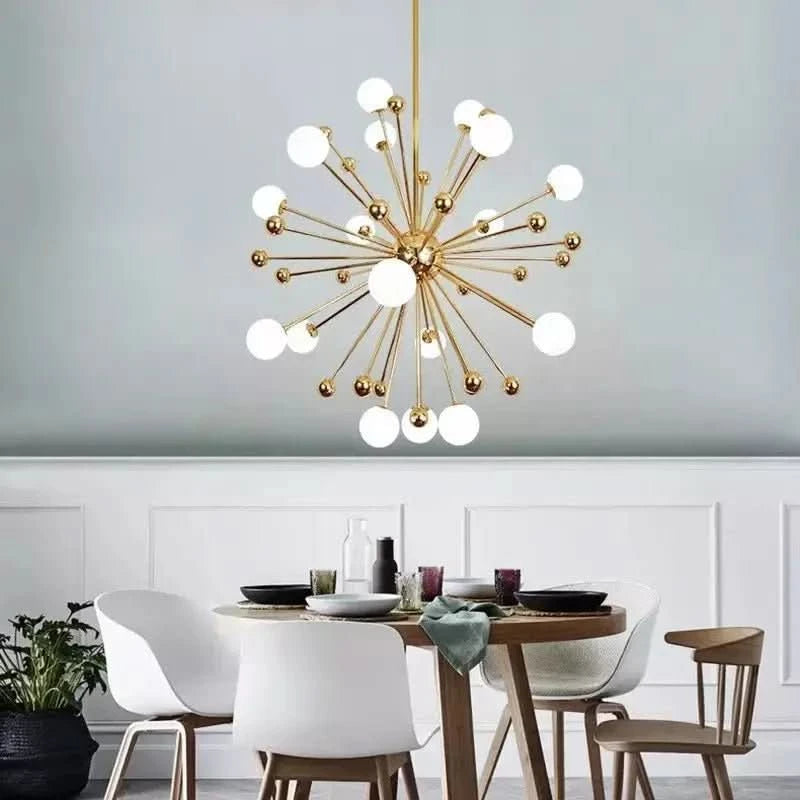 Vue de face du luminaire sphérique doré suspendu dans une salle à manger blanche.