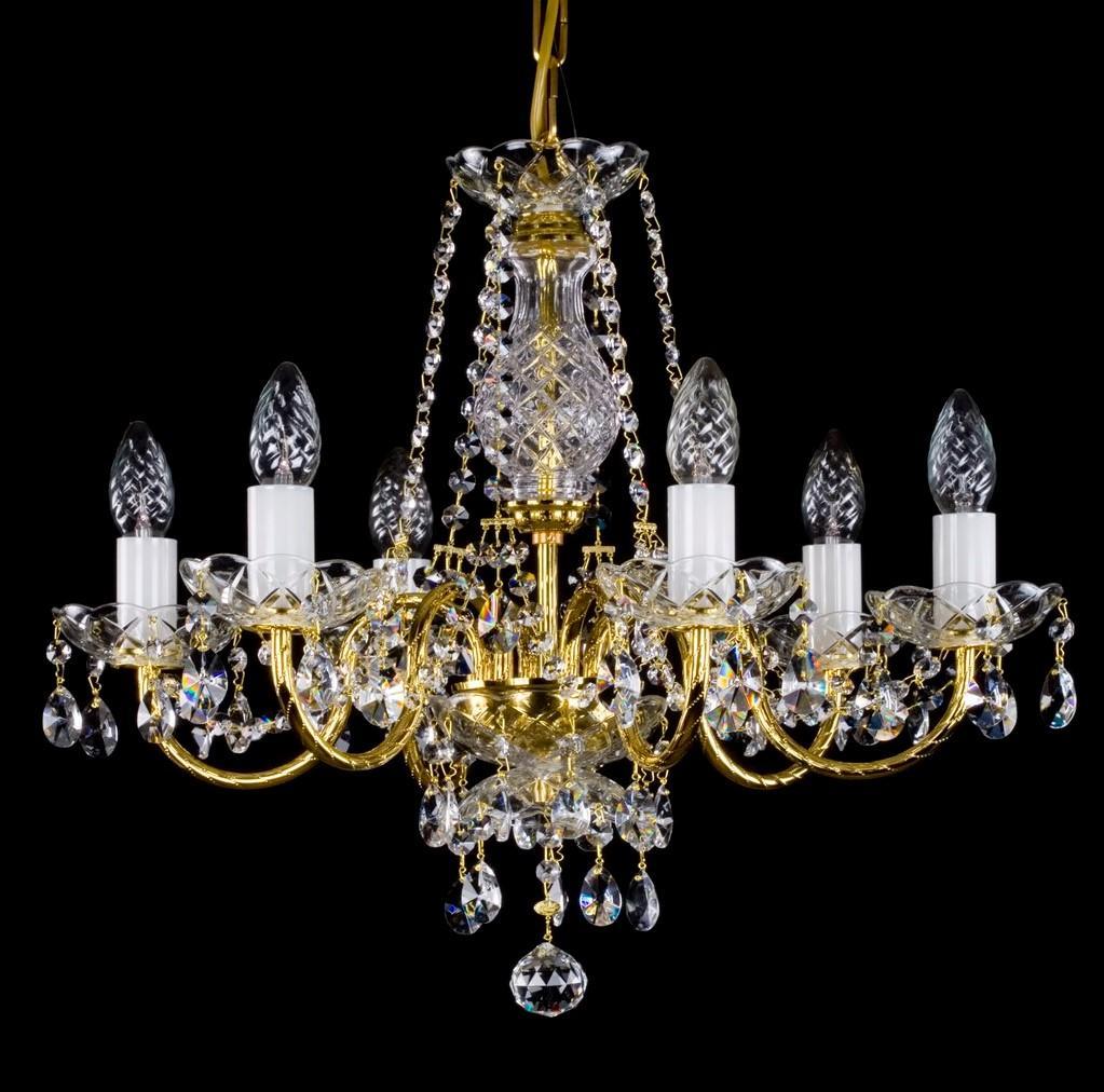Lustre doré à cinq bras vu de face sur fond noir, cristal et pampilles