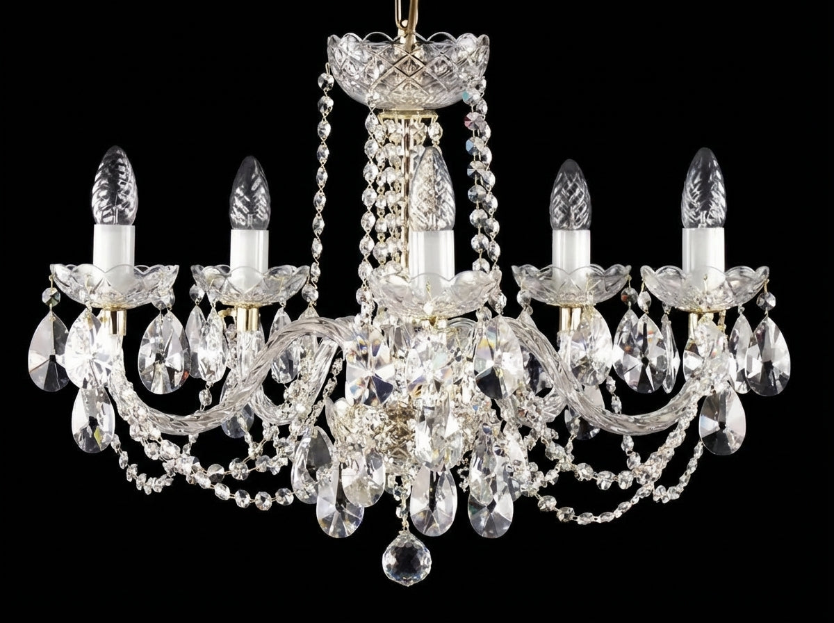 Lustre cinq branches en cristal, ampoules éteintes, présenté sur fond noir uni