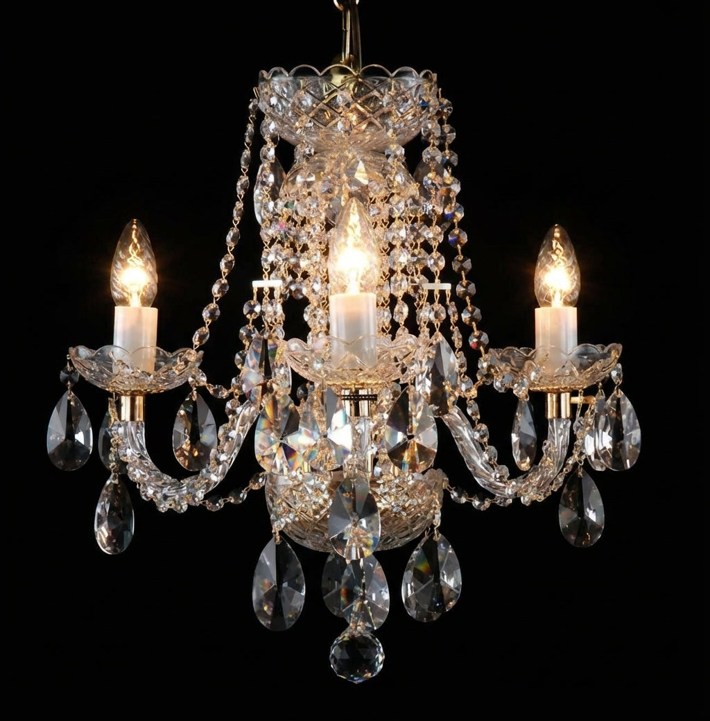 Lustre en cristal trois bras allumé, vue de face sur fond noir