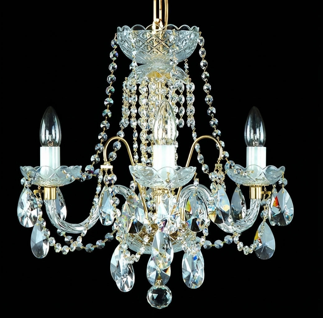 Lustre en cristal doré à trois bras, éteint, présenté sur fond noir