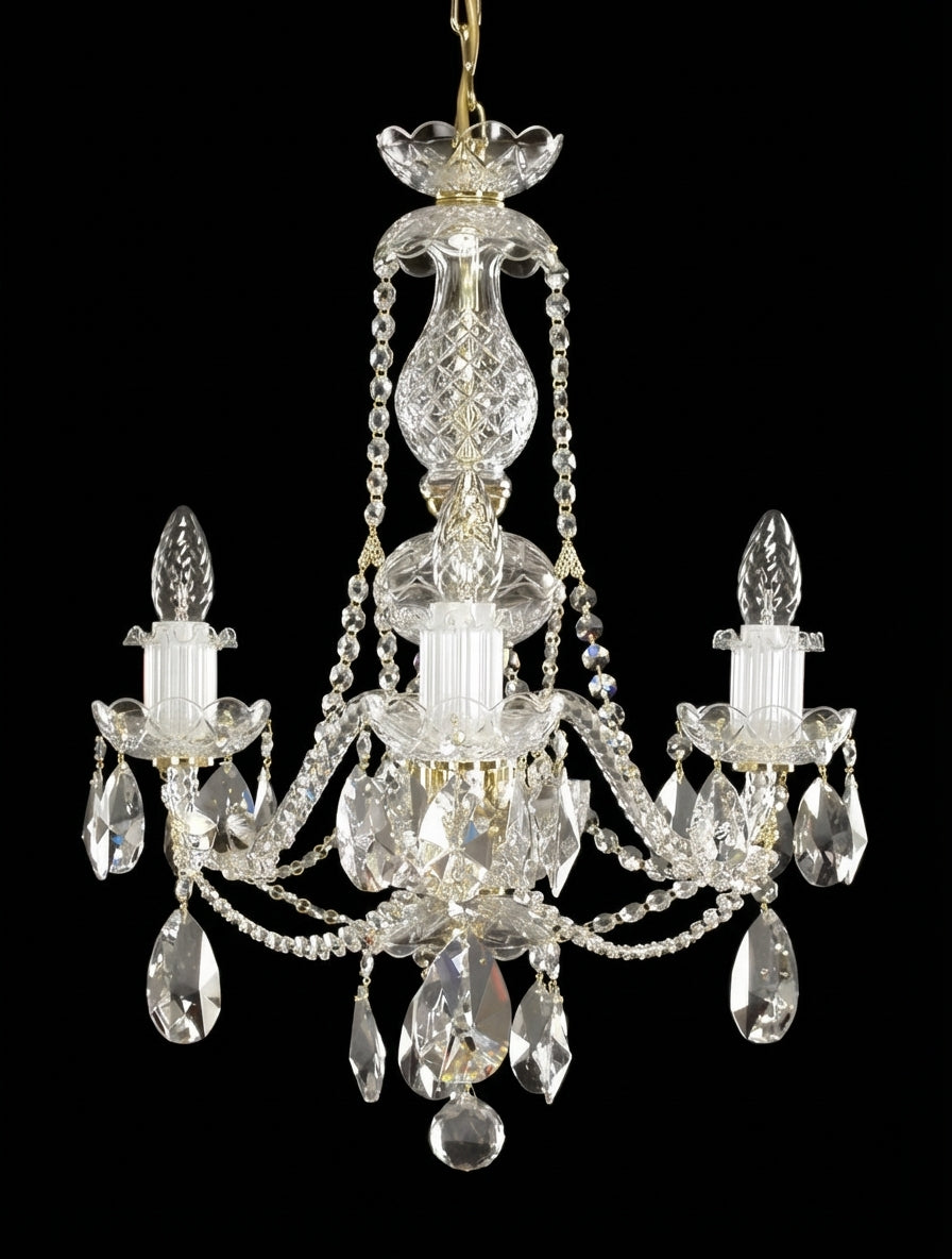 Lustre en cristal à trois bras, éteint, présenté de face sur fond noir.