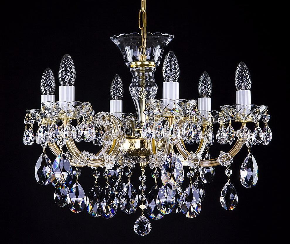 Lustre doré à huit bras, pampilles de cristal taillé, vu de face sur fond noir