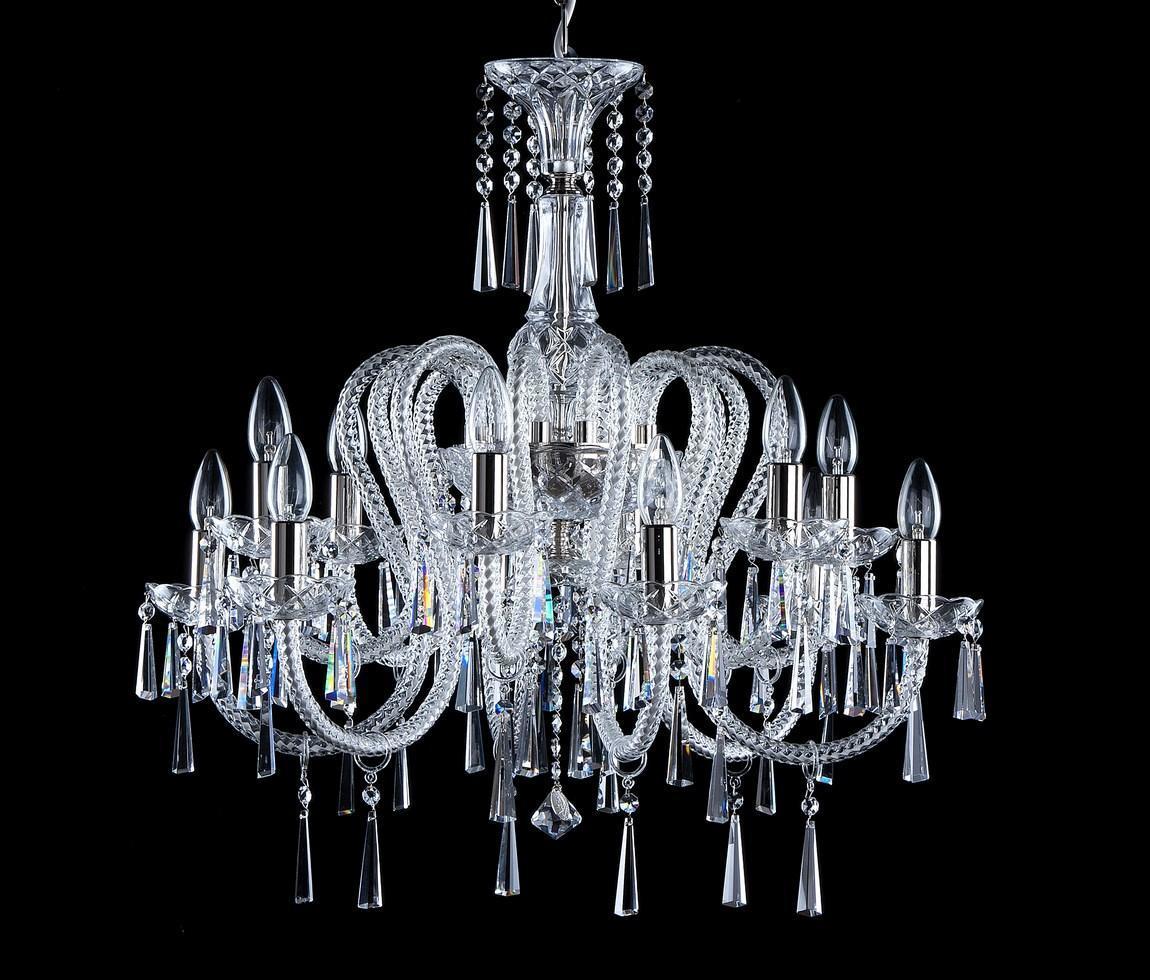 Lustre en cristal de face sur fond noir, bras courbés et pendeloques visibles