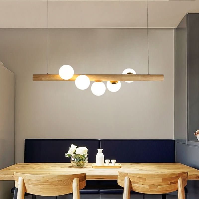 Ambiance repas avec la suspension bois et ses globes sur banquette bleue