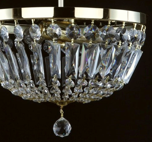 Gros plan sur les pampilles et prismes de cristal taillé suspendus à la couronne