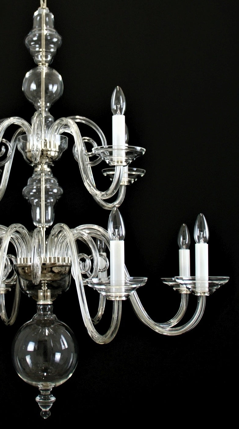 Vue rapprochée du lustre montrant bras de verre recourbés et coupelles transparentes