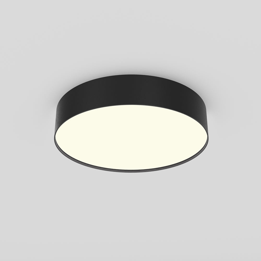 Plafonnier rond noir vu de dessous, large diffuseur blanc uniformément allumé.