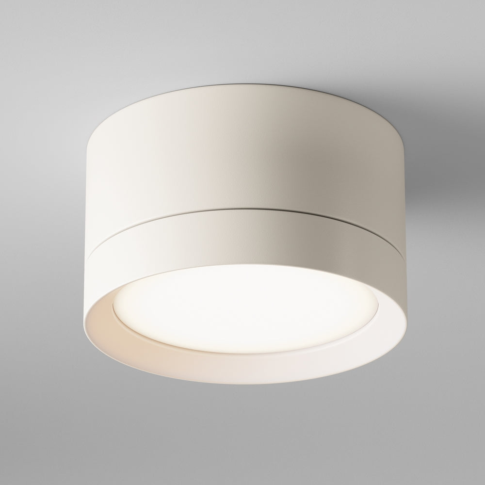 Plafonnier cylindrique blanc vu de face, monté au plafond sur fond gris.