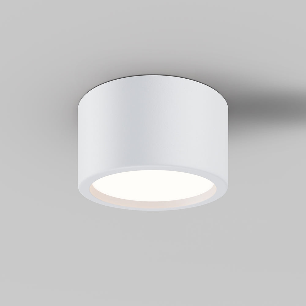 Plafonnier cylindrique blanc fixé au plafond, vue de trois quarts éclairé