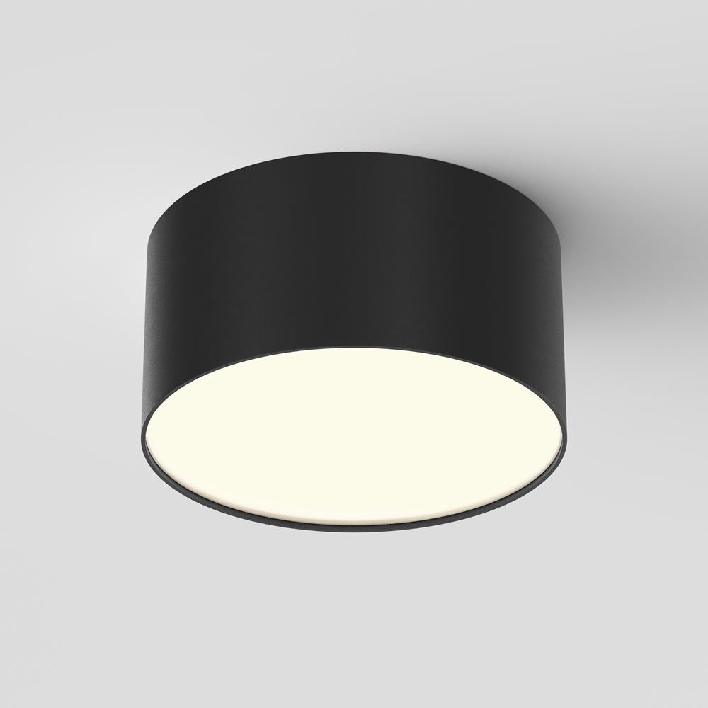 Plafonnier cylindrique noir vu de face avec diffuseur blanc laiteux allumé