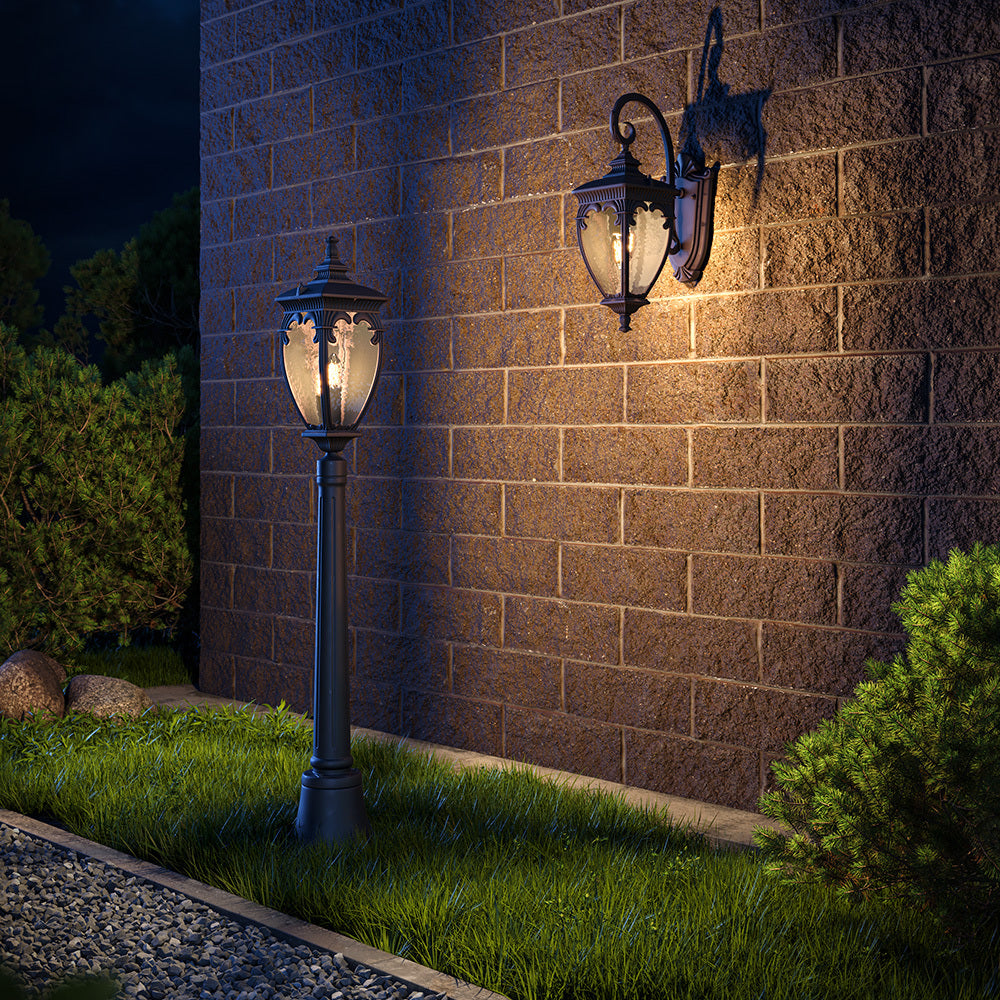 Mise en ambiance nocturne : lampadaire et applique murale éclairant un mur en pierre