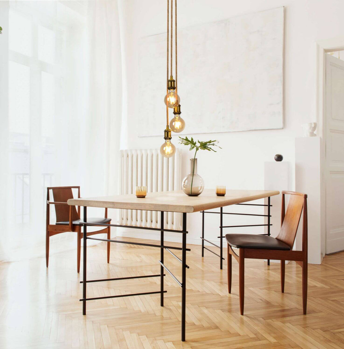 Suspension éclairée au-dessus d'une table de salle à manger en bois clair