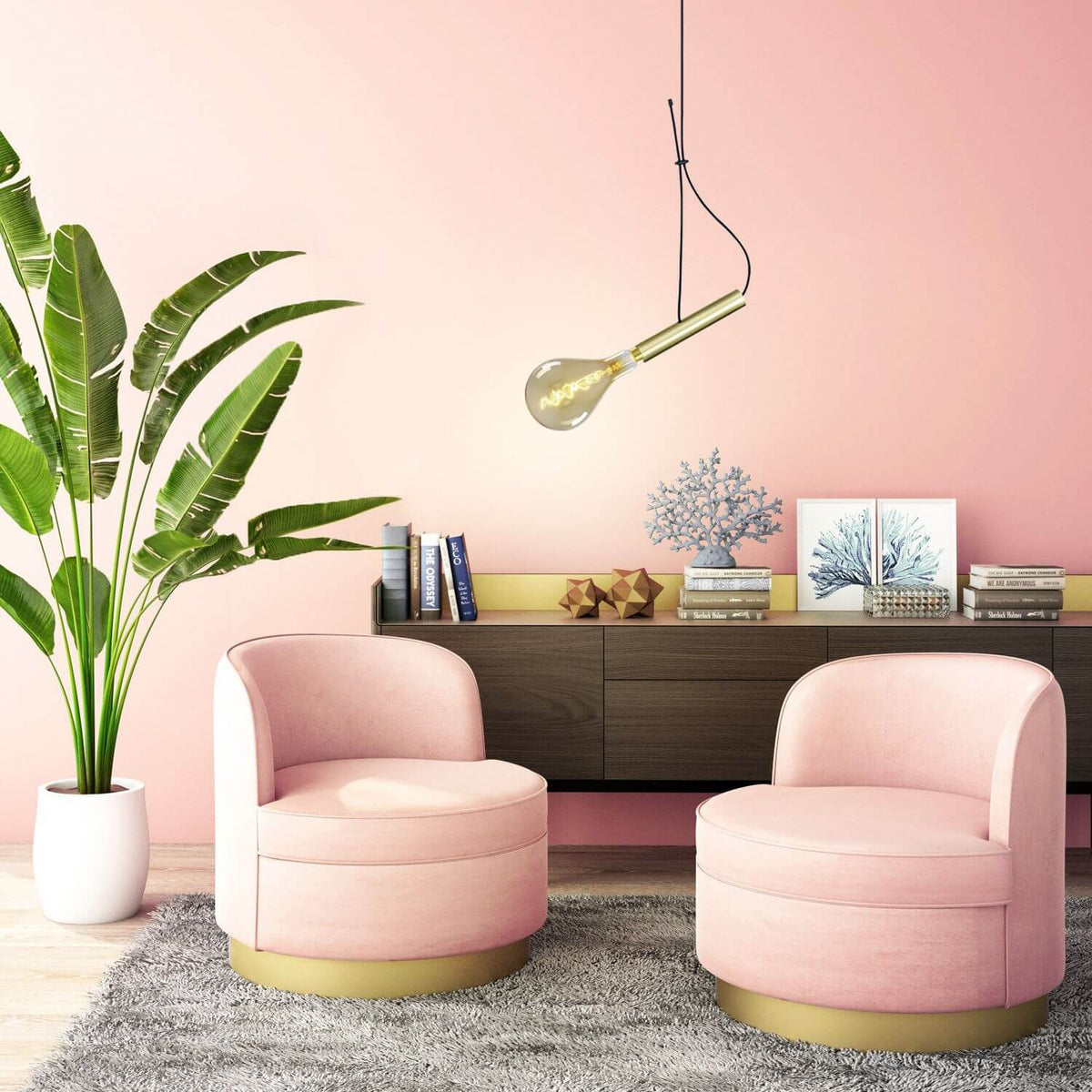 Suspension dorée allumée dans un salon rose avec fauteuils en velours et plante.
