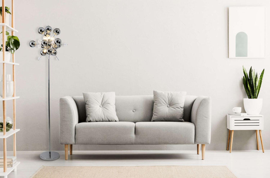 Lampadaire en situation dans un séjour moderne avec canapé gris et étagère en bois.