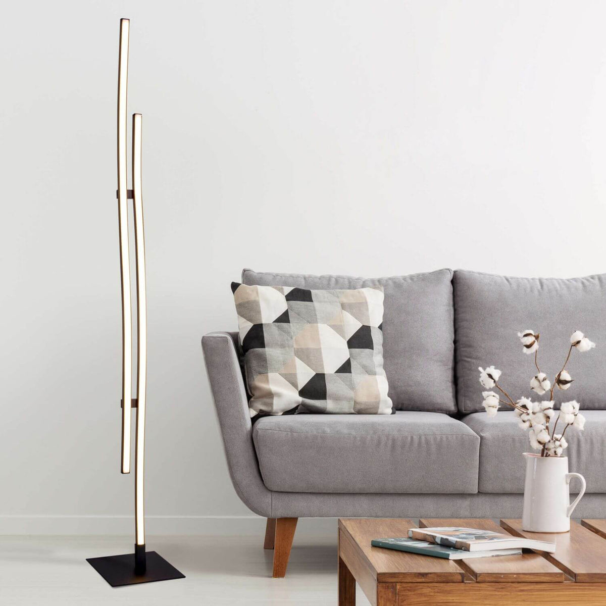 Mise en ambiance du lampadaire près d'un canapé gris et coussin géométrique