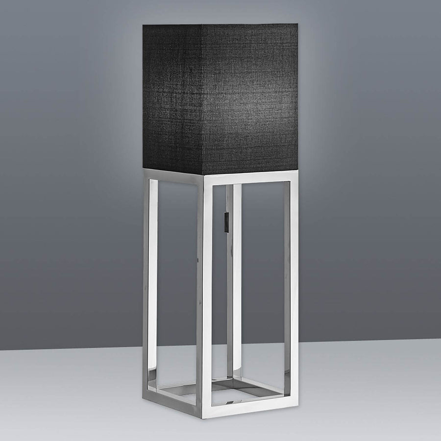 Présentation du luminaire sur fond gris, abat-jour carré en tissu et piètement métallique.