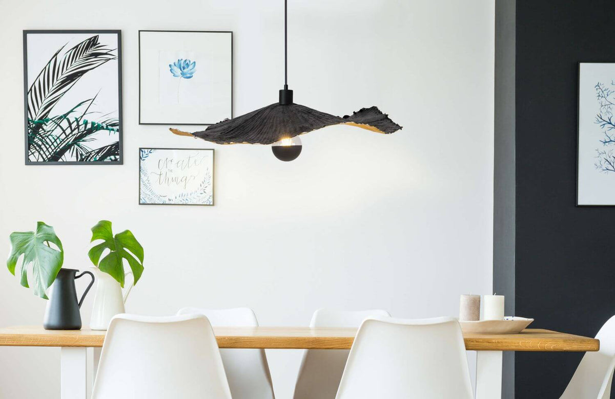Suspension noire suspendue au-dessus d'une table dans une salle à manger contemporaine.