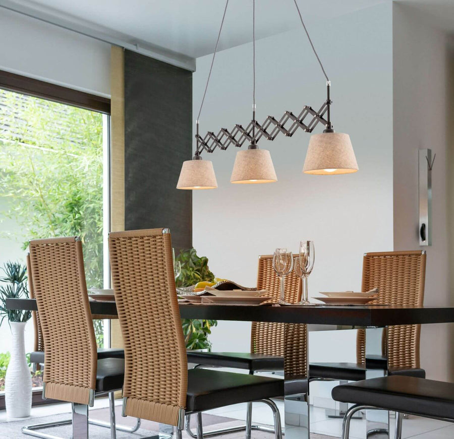 Suspension éclairée au-dessus d'une table de salle à manger avec chaises en cannage