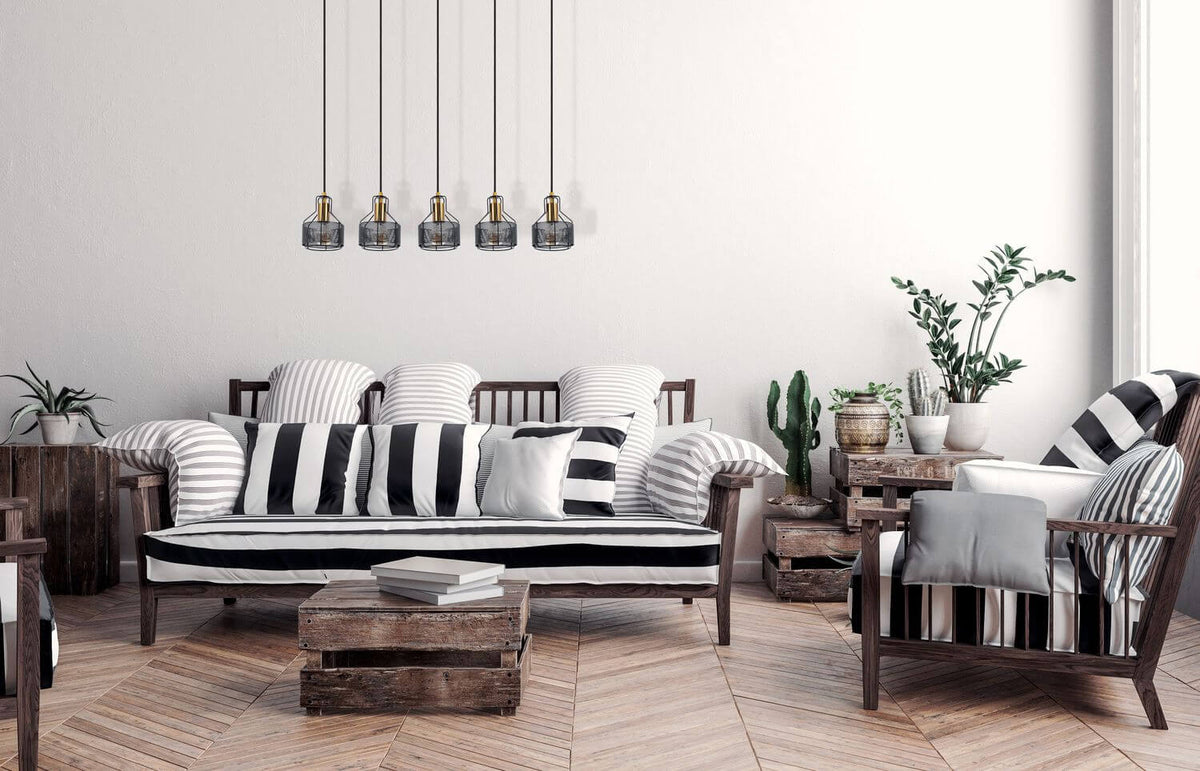 Mise en ambiance salon, cinq suspensions noires au-dessus d'un canapé rayé noir et blanc