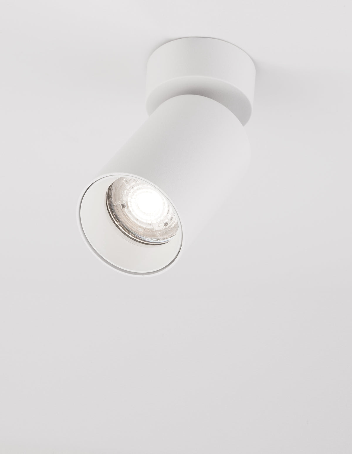 Spot blanc incliné sur fond blanc avec sa lentille LED allumée