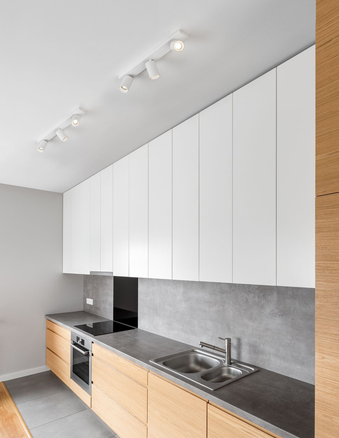 Plafonnier blanc fixé au plafond d'une cuisine moderne au-dessus du plan de travail