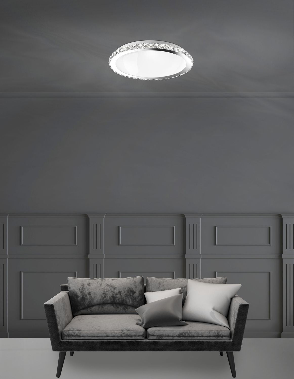 Mise en ambiance d'un salon gris avec canapé, plafonnier rond allumé fixé au plafond.