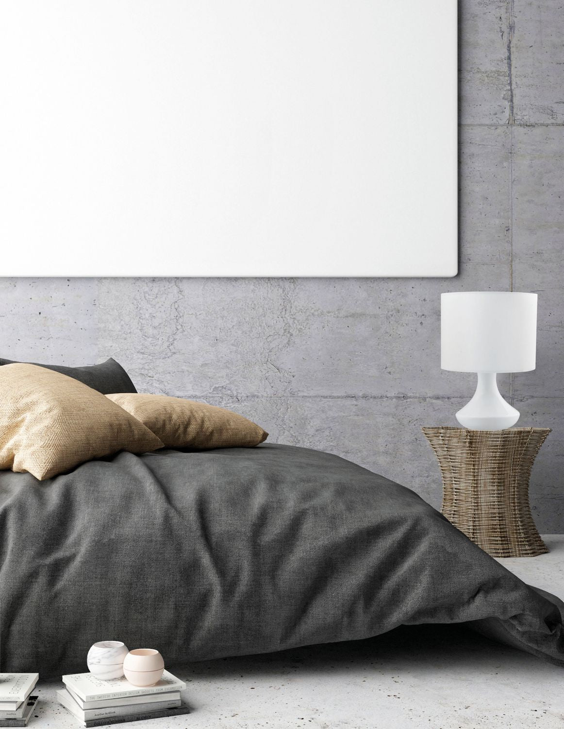 Lampe blanche posée sur une table en rotin près d'un lit en ambiance chambre