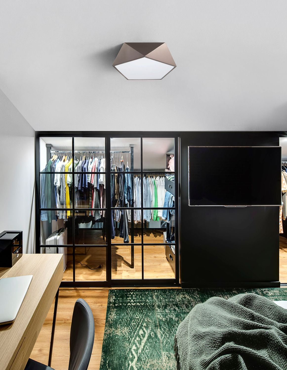 Plafonnier hexagonal fixé au plafond dans une pièce avec dressing vitré et écran