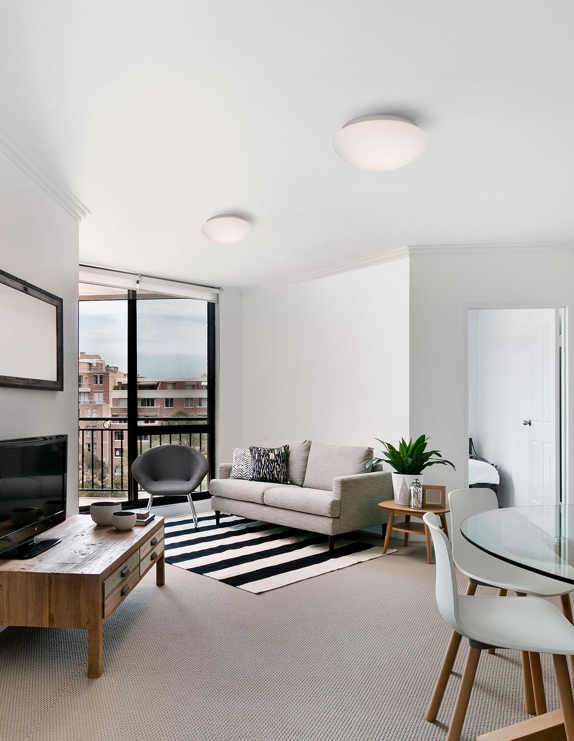 Salon contemporain avec deux plafonniers ronds blancs fixés au plafond, vue d'ambiance