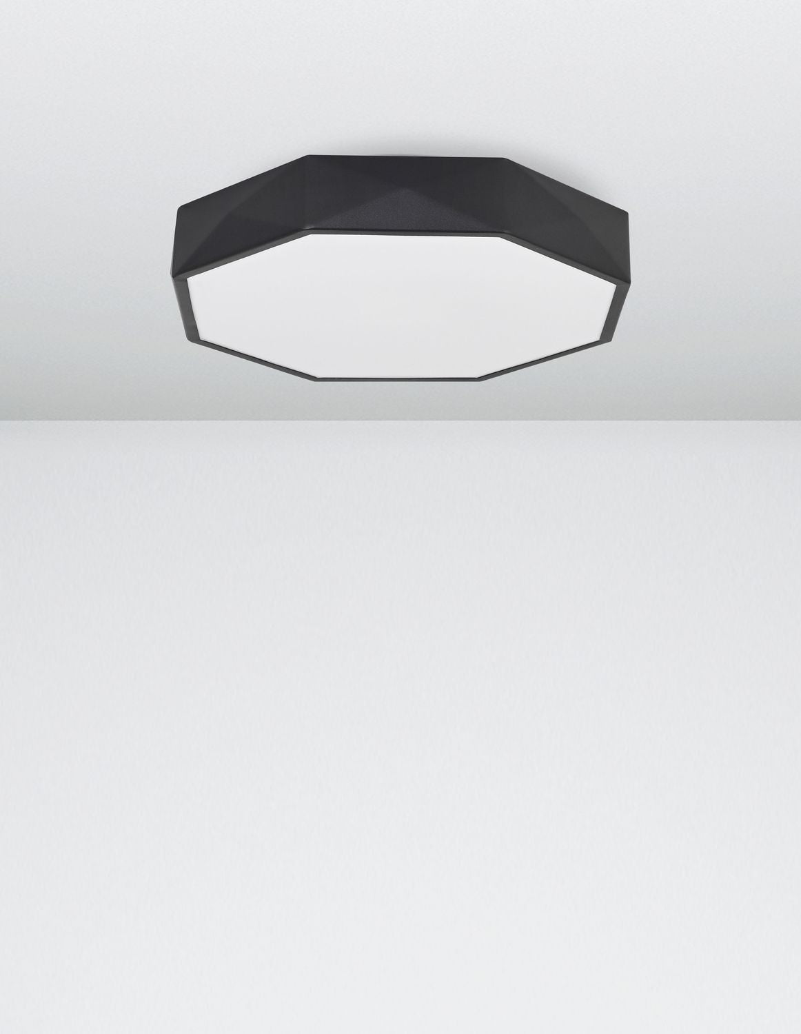 Plafonnier noir fixé au plafond blanc, vu de dessous en situation