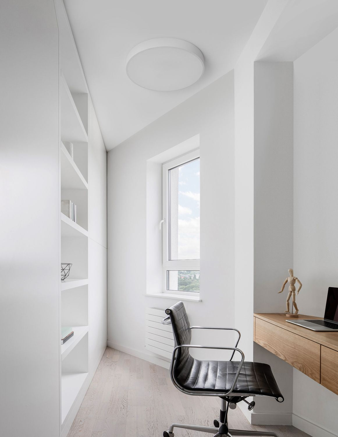 Vue d'ensemble du plafonnier rond blanc installé au plafond d'un bureau clair