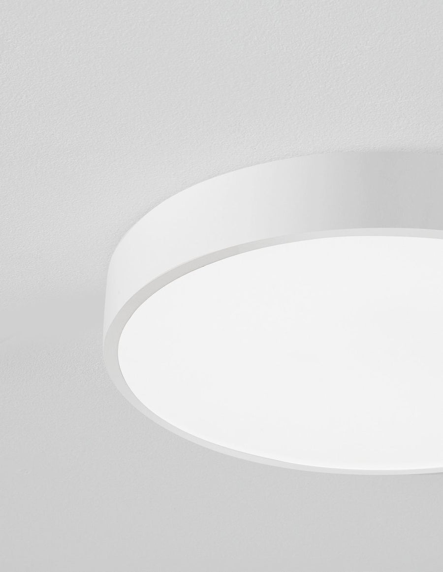Détail macro du bord du luminaire et de la texture mate du plafond