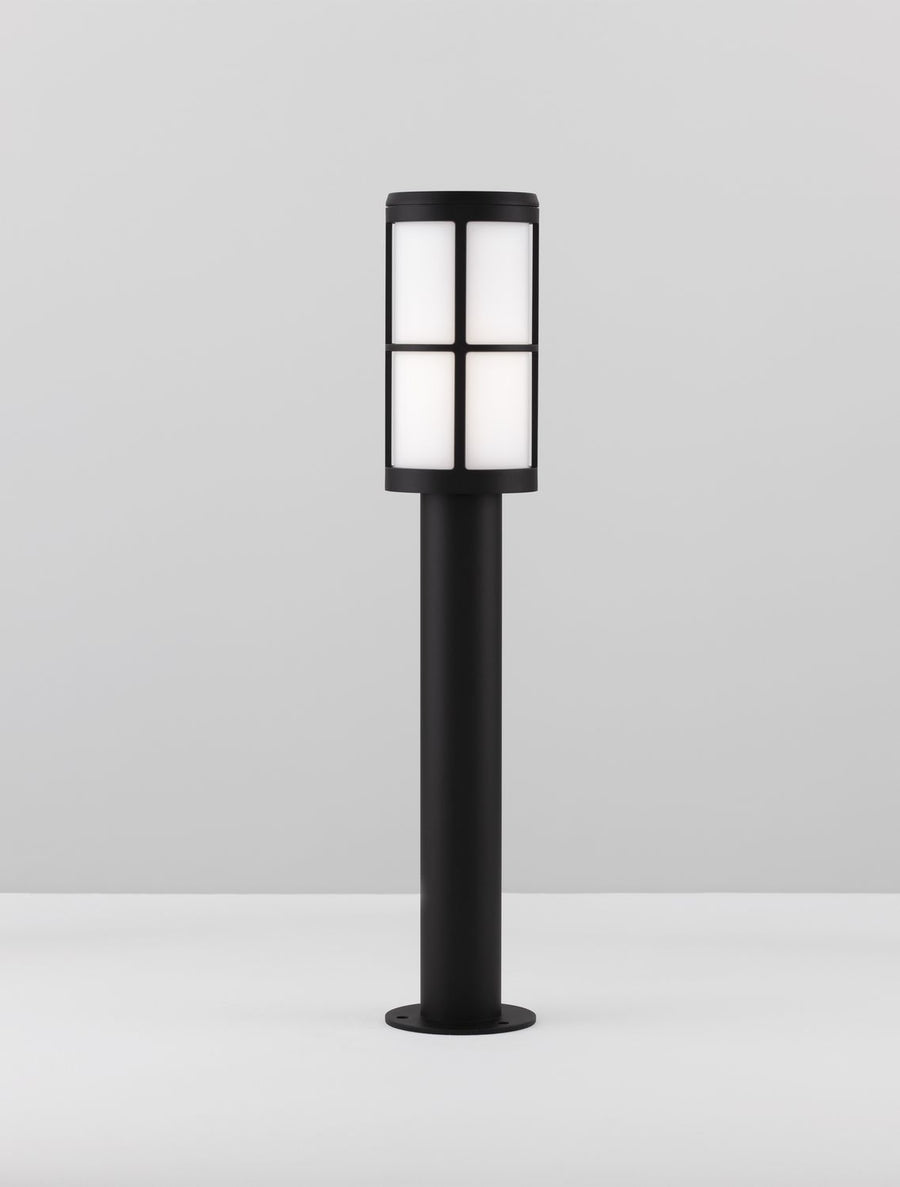 Luminaire présenté debout sur un plan gris, base circulaire et mât cylindrique
