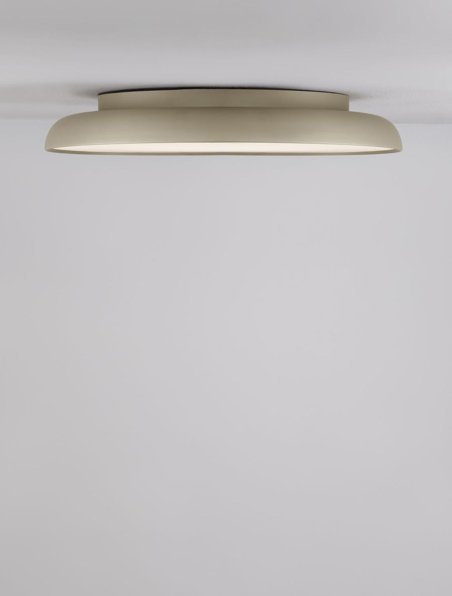 Plafonnier doré allumé fixé au plafond, vue de dessous sur fond blanc