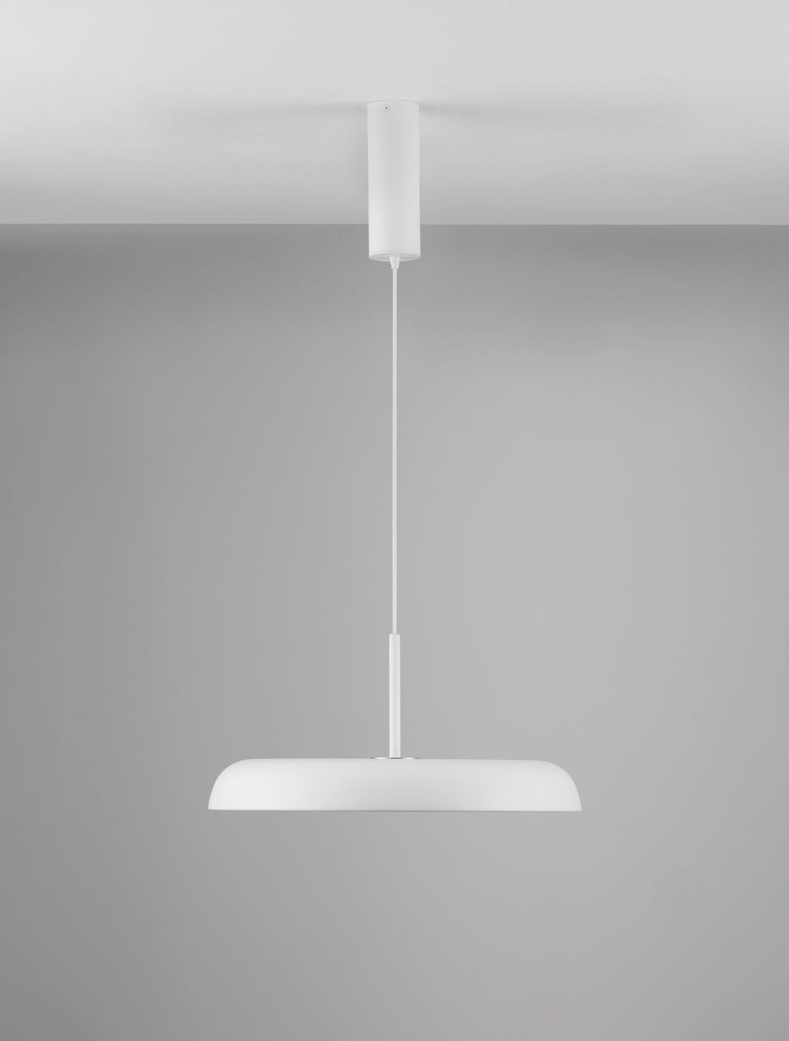 Suspension blanche vue de face sur fond gris, câble et rosace cylindrique visibles