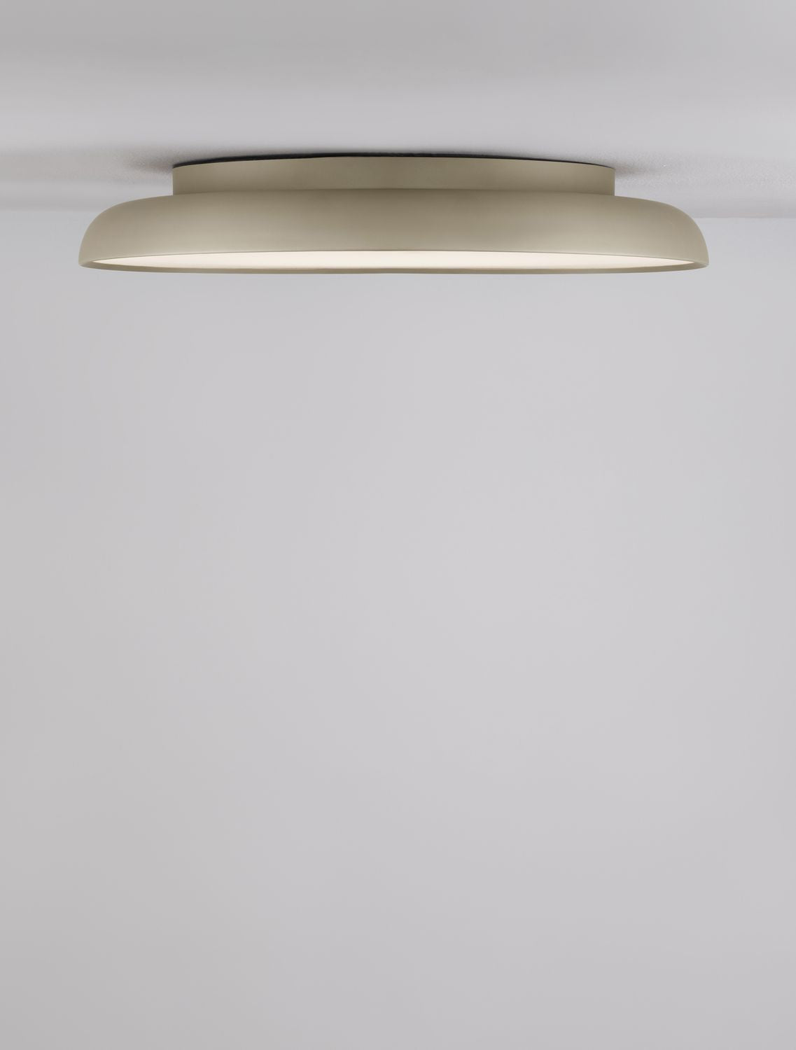 Plafonnier doré allumé vu de dessous, fixé au plafond d'une pièce claire