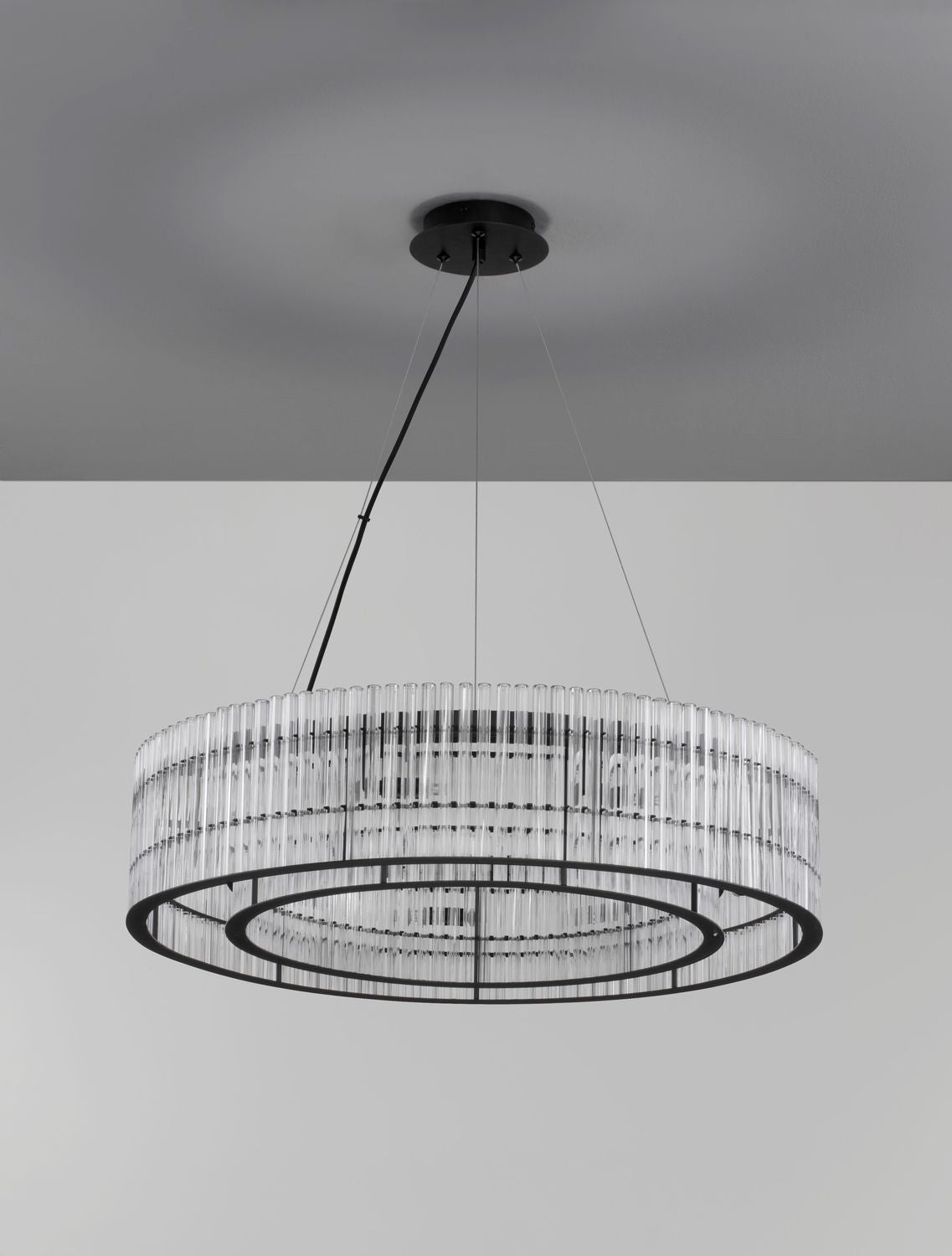Vue en légère contre-plongée, suspension allumée sous un plafond gris