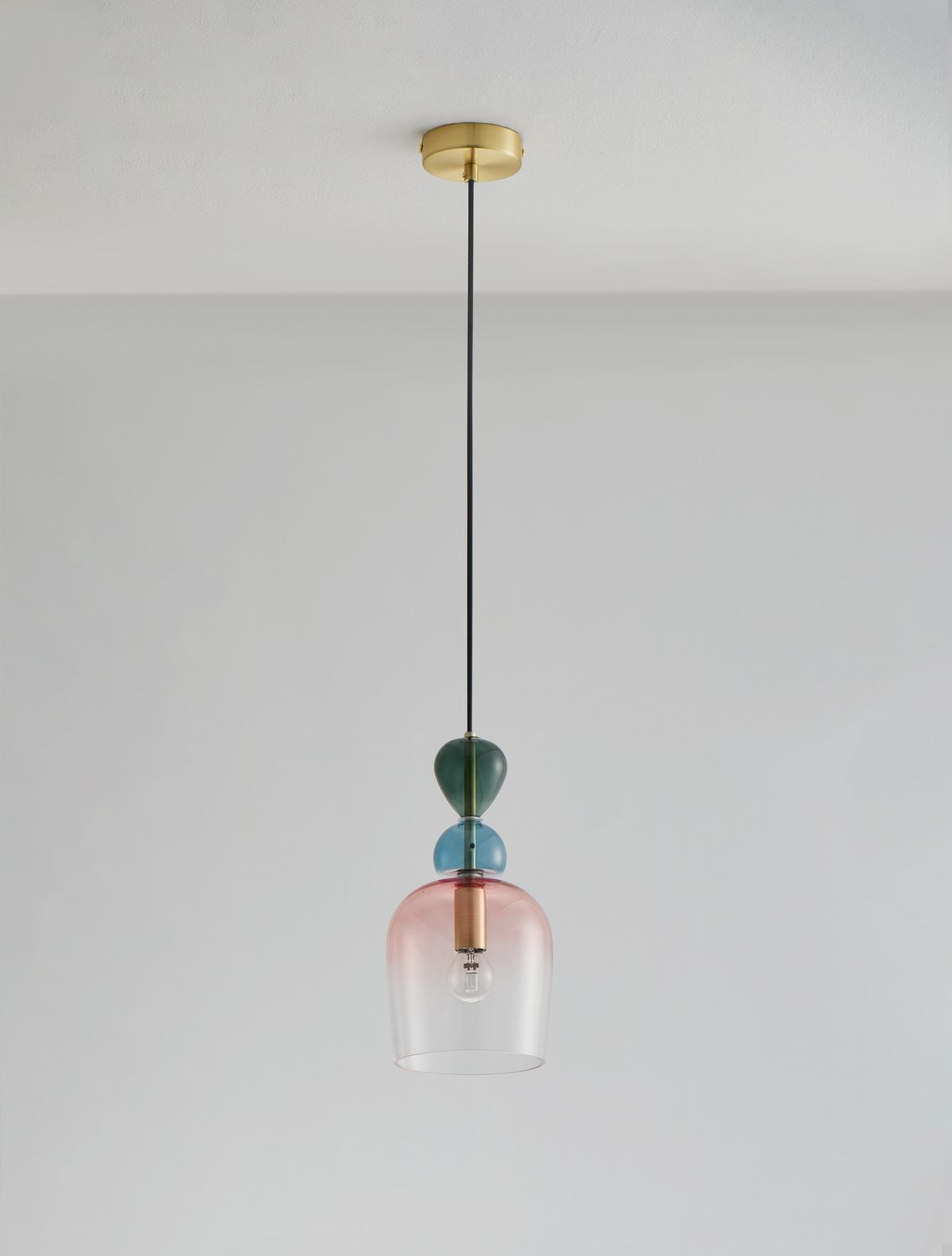 Suspension suspendue au plafond devant un mur gris, lumière allumée.