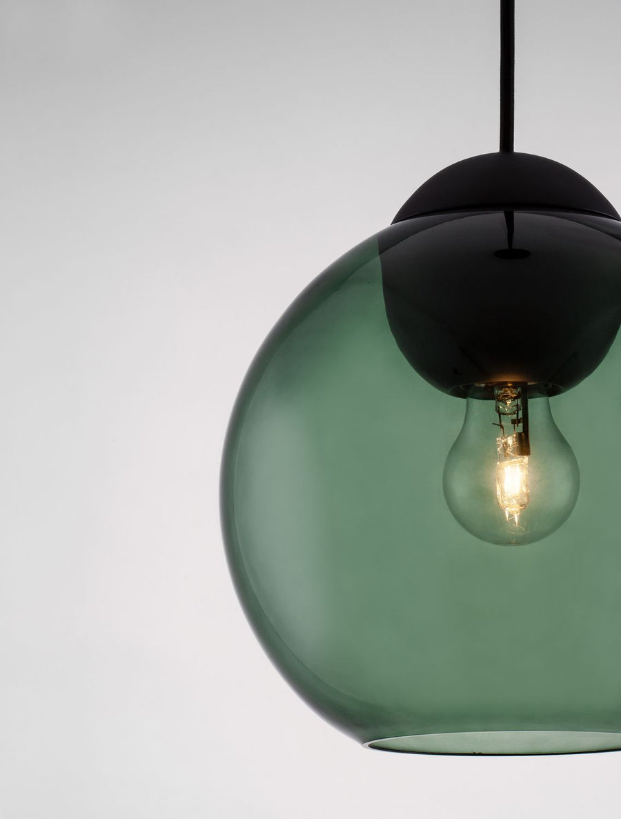 Détail rapproché de l'ampoule allumée à l'intérieur du globe en verre vert