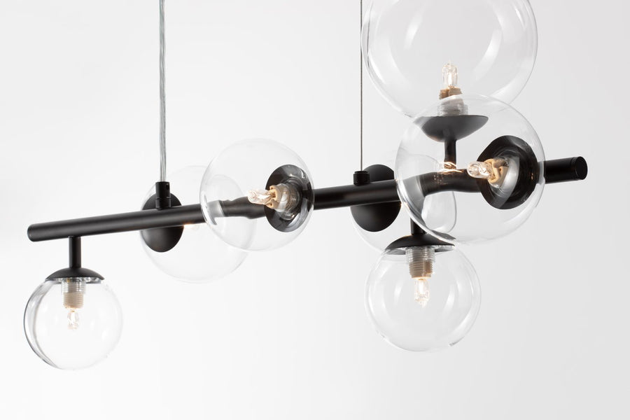 Détail des sphères en verre et de la barre métallique noire avec douilles apparentes