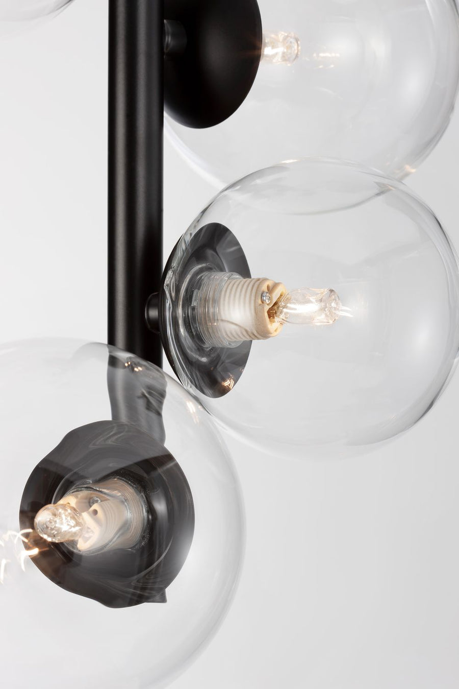 Gros plan sur un globe transparent, douille noire et ampoule à filament allumée