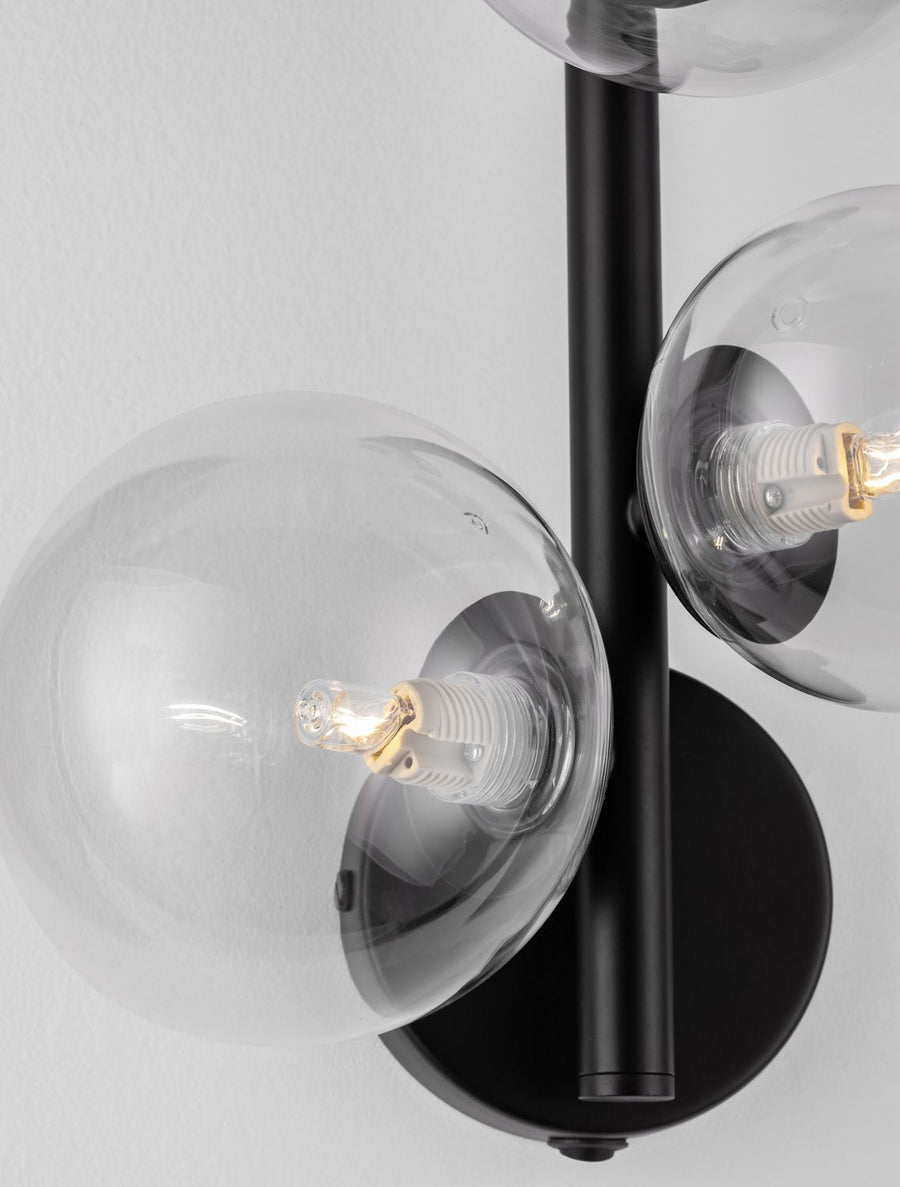 Gros plan sur une sphère de verre et l'ampoule à filament allumée.