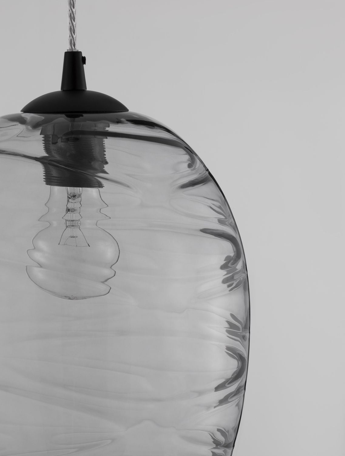 Gros plan sur la texture ondulée du verre et le raccord métallique noir